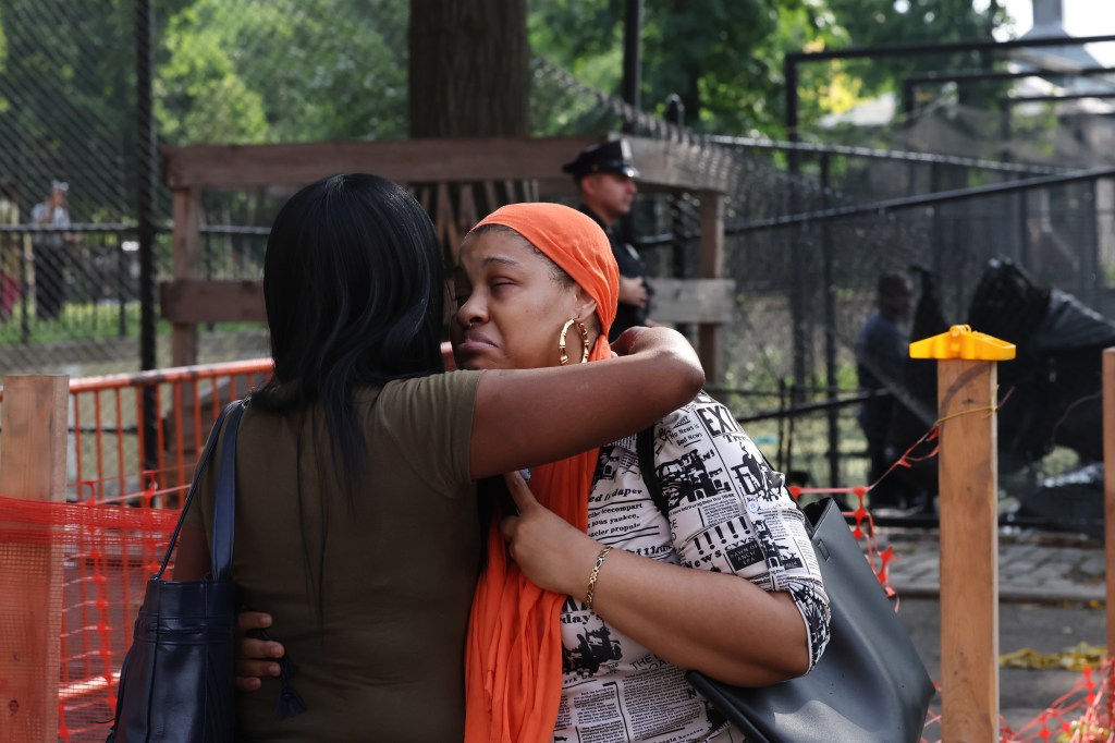 Haneefah Hadsan, cousin and niece of victims Herman and his mom, cries while being embraced at the scene of a fatal MVA in the Lower East Side of Manhattan.