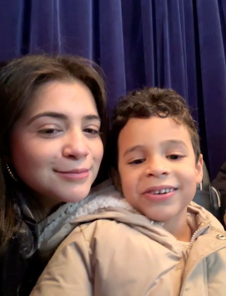 Emily and Kal-El with a blue curtain in the background.