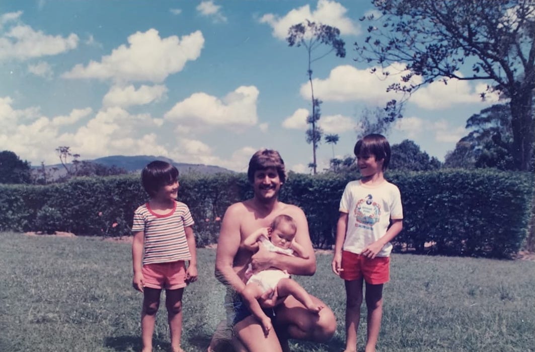 A man with his three kids posing in a field in Blantyre, Malawi.