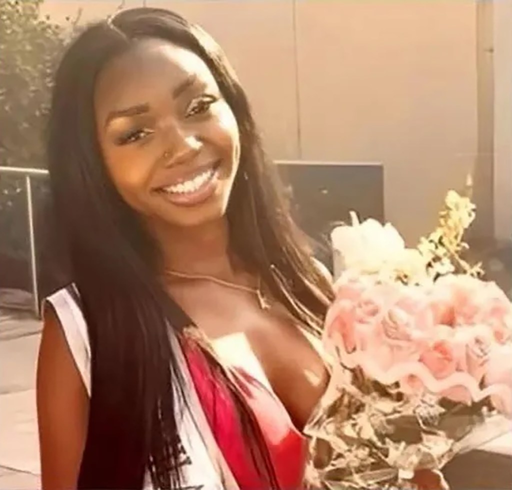 Kada Scott, a Black woman, smiling and holding a bouquet of pink roses.