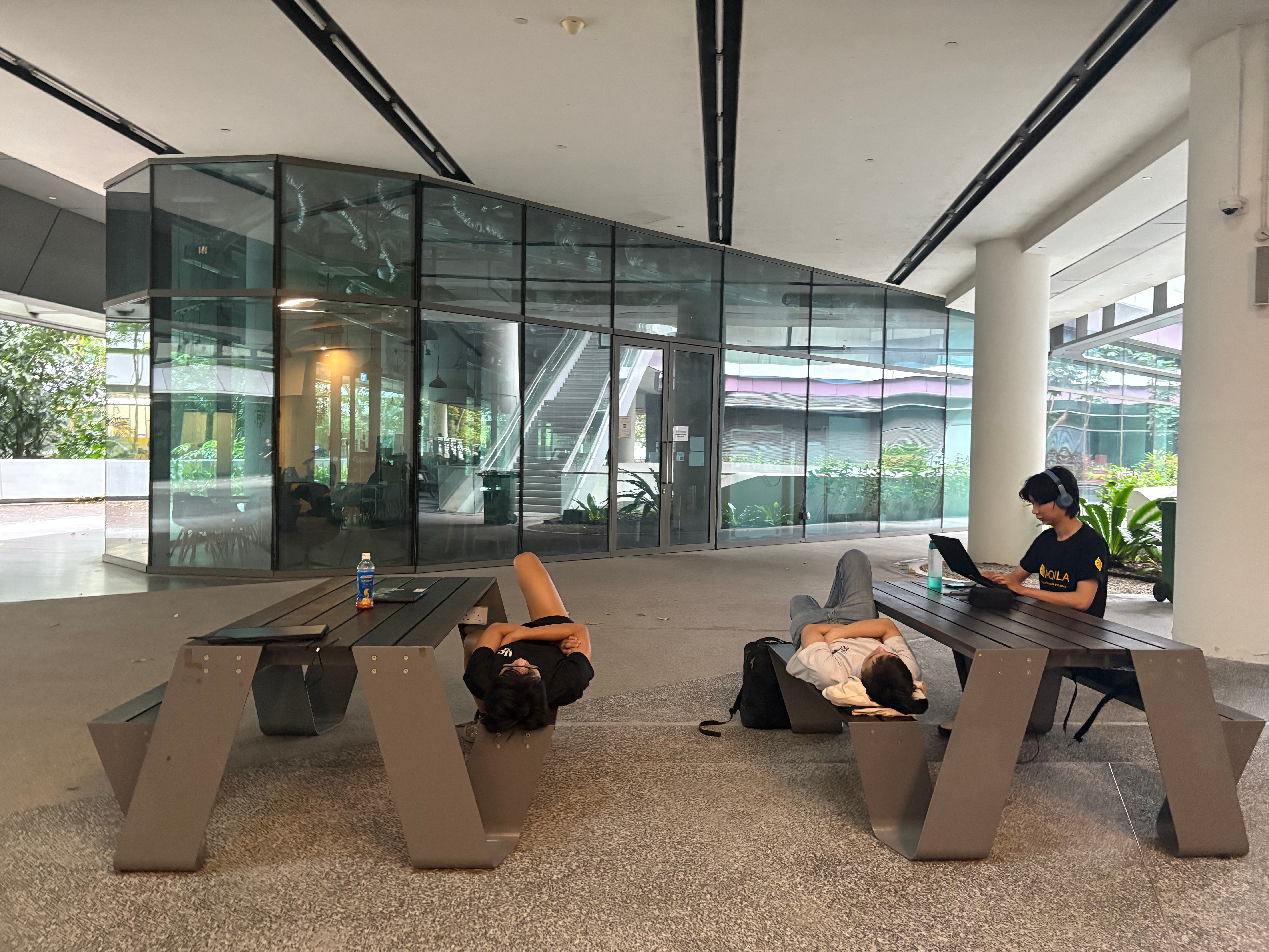 Participants sleeping on benches outside the lecture hall