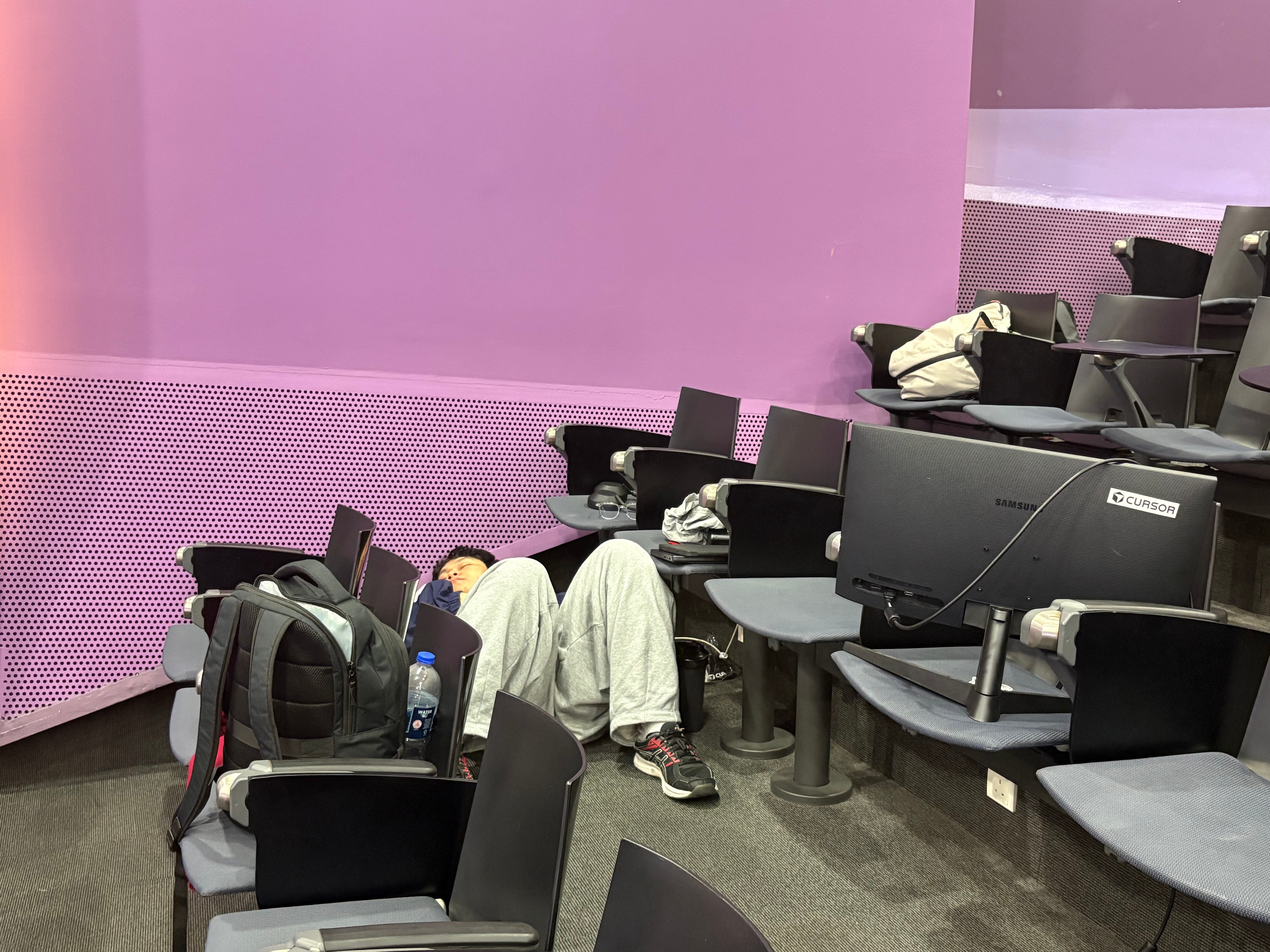 Man sleeping on the floor in lecture hall