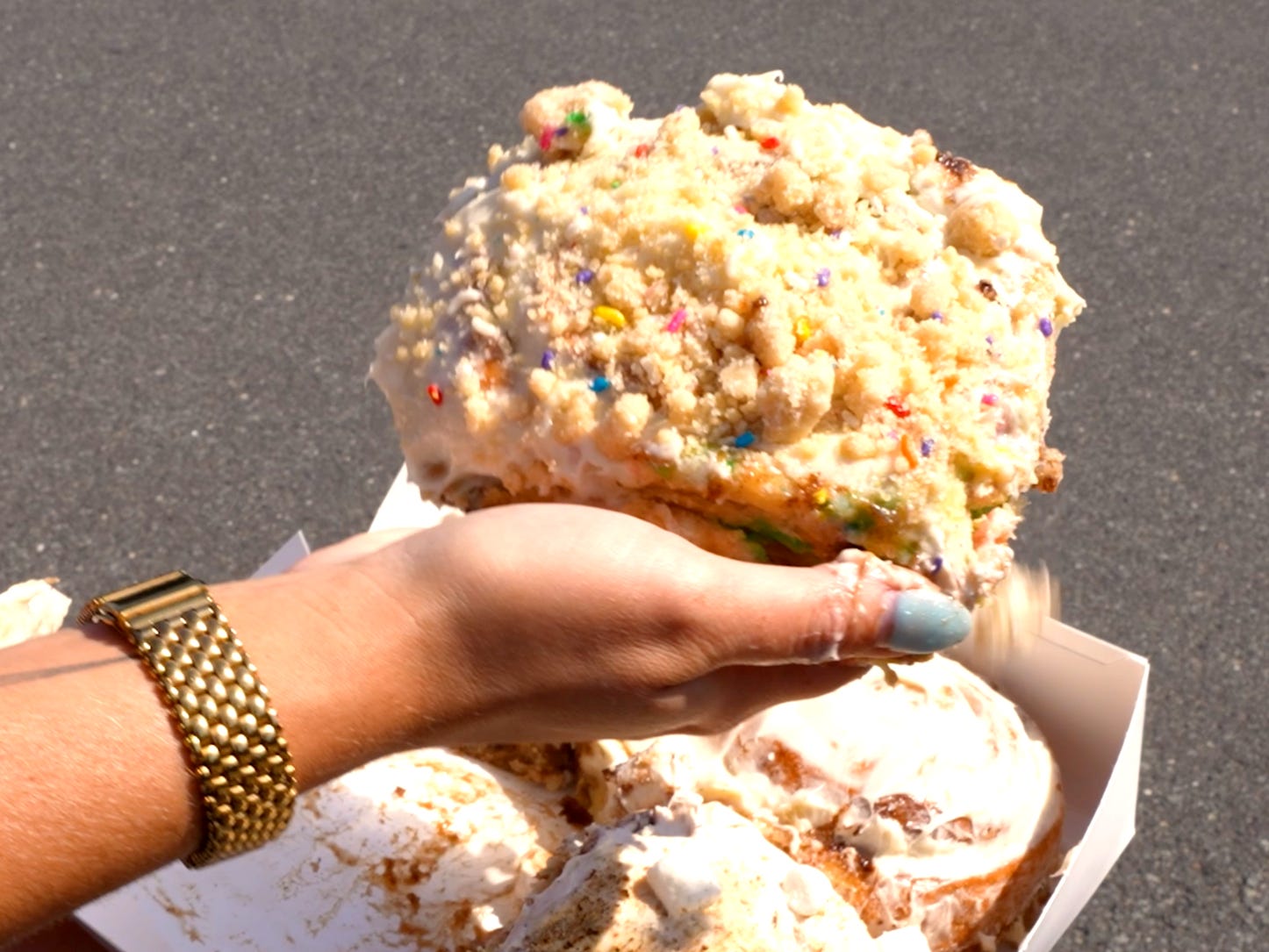 A cinnamon bun covered in crumble and sprinkles