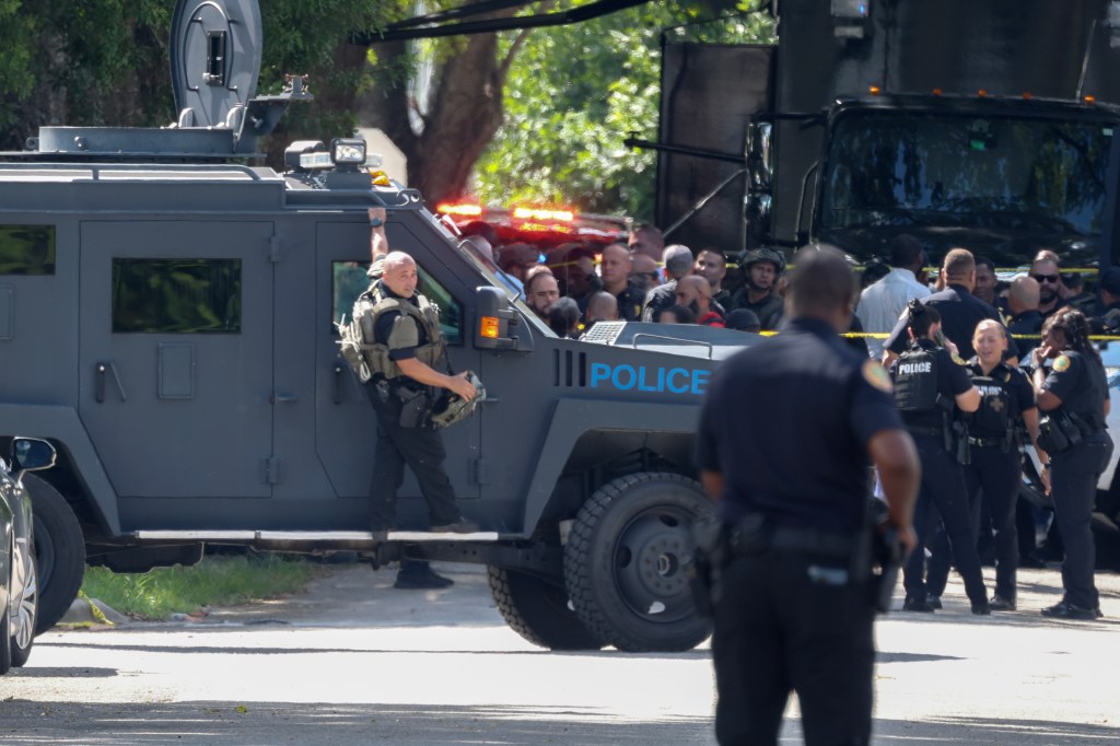 Police officer standing next to an armored police vehicle.