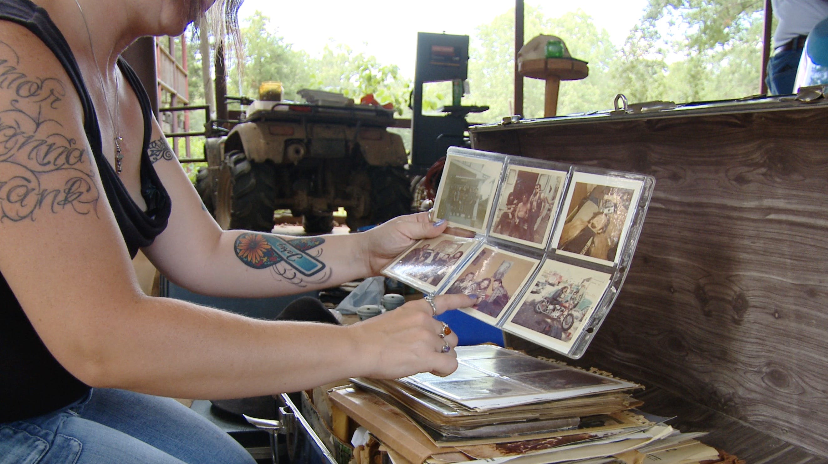 A person pointing at a bunch of old pictures in a picture book.