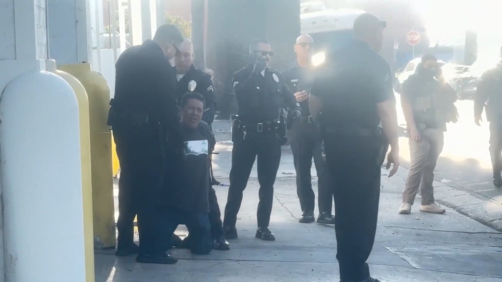 Police detain Carlitos Ricardo Parias after the shooting in Southern Los Angeles.