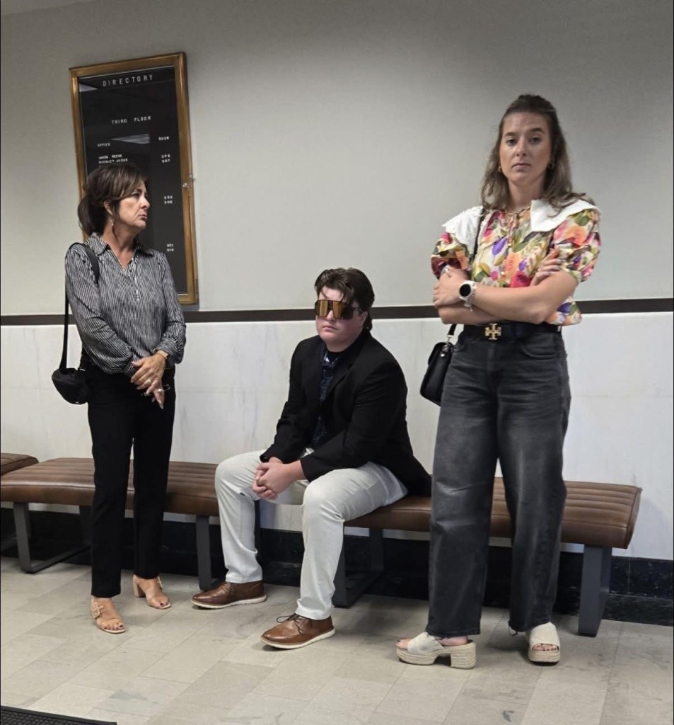 Butler surrounded by his mother and sister in court.