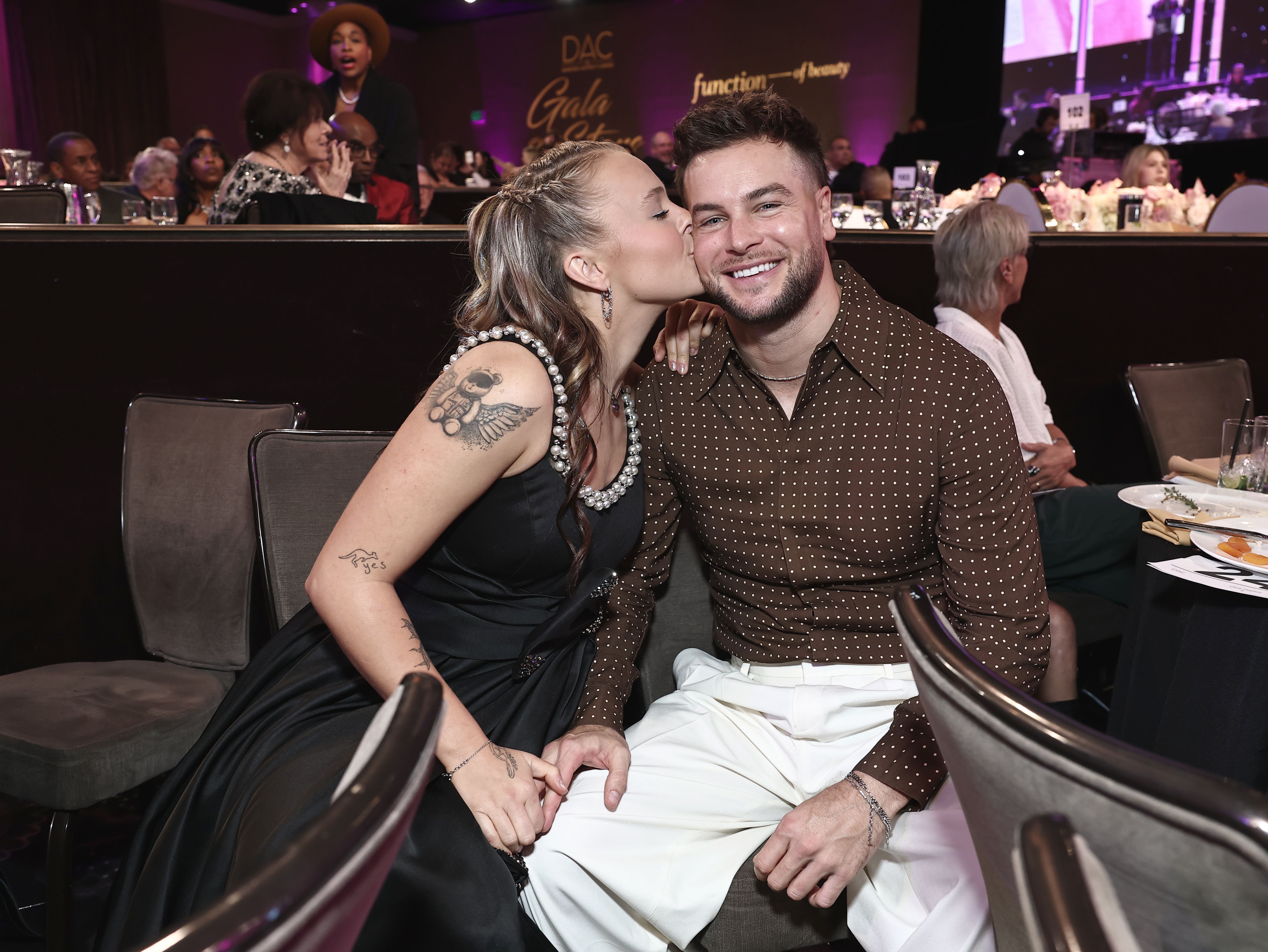 JoJo Siwa kissing Chris Hughes on the cheek at the Dancers Against Cancer Gala.