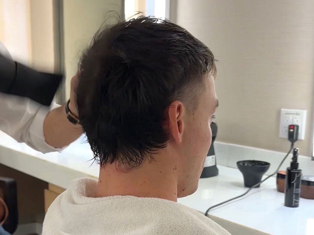 A man with a short mullet that incorporates faded sides.