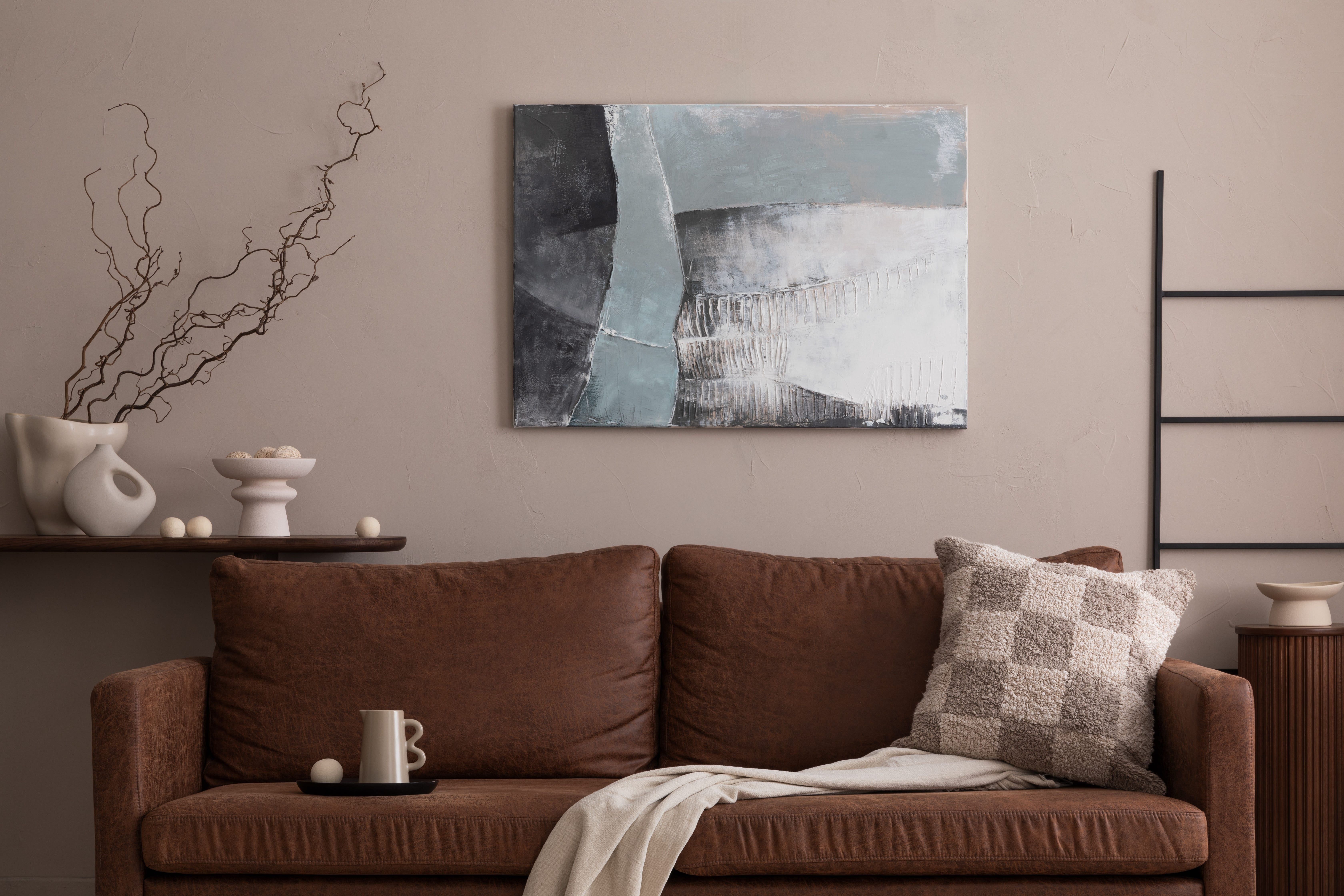 A brown couch with a throw pillow.