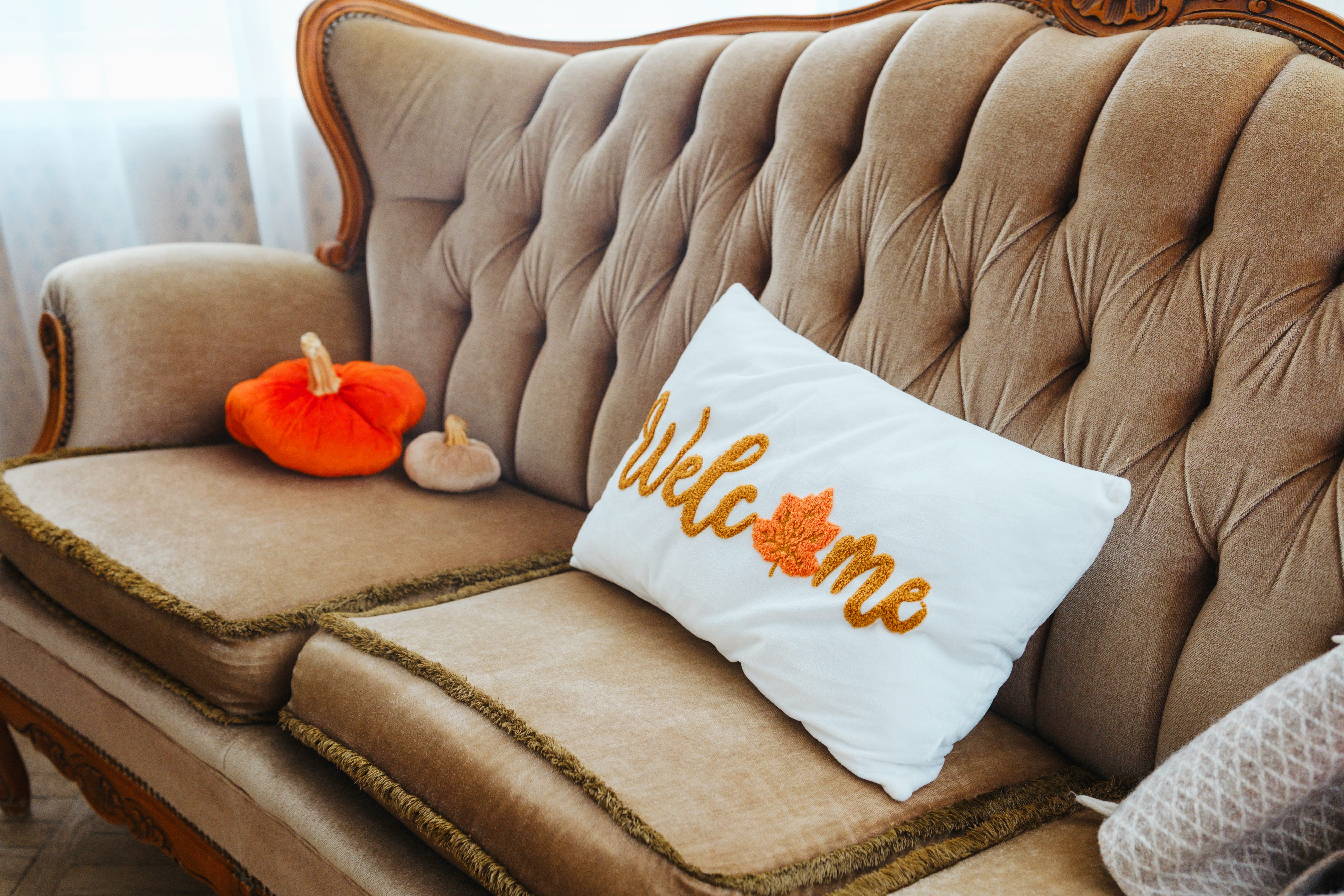 Pillows that look like pumpkins on a sofa.