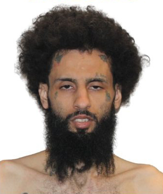 Mugshot of Corree Gonzales, a man with a large beard, tattoos on his face, and dark curly hair.