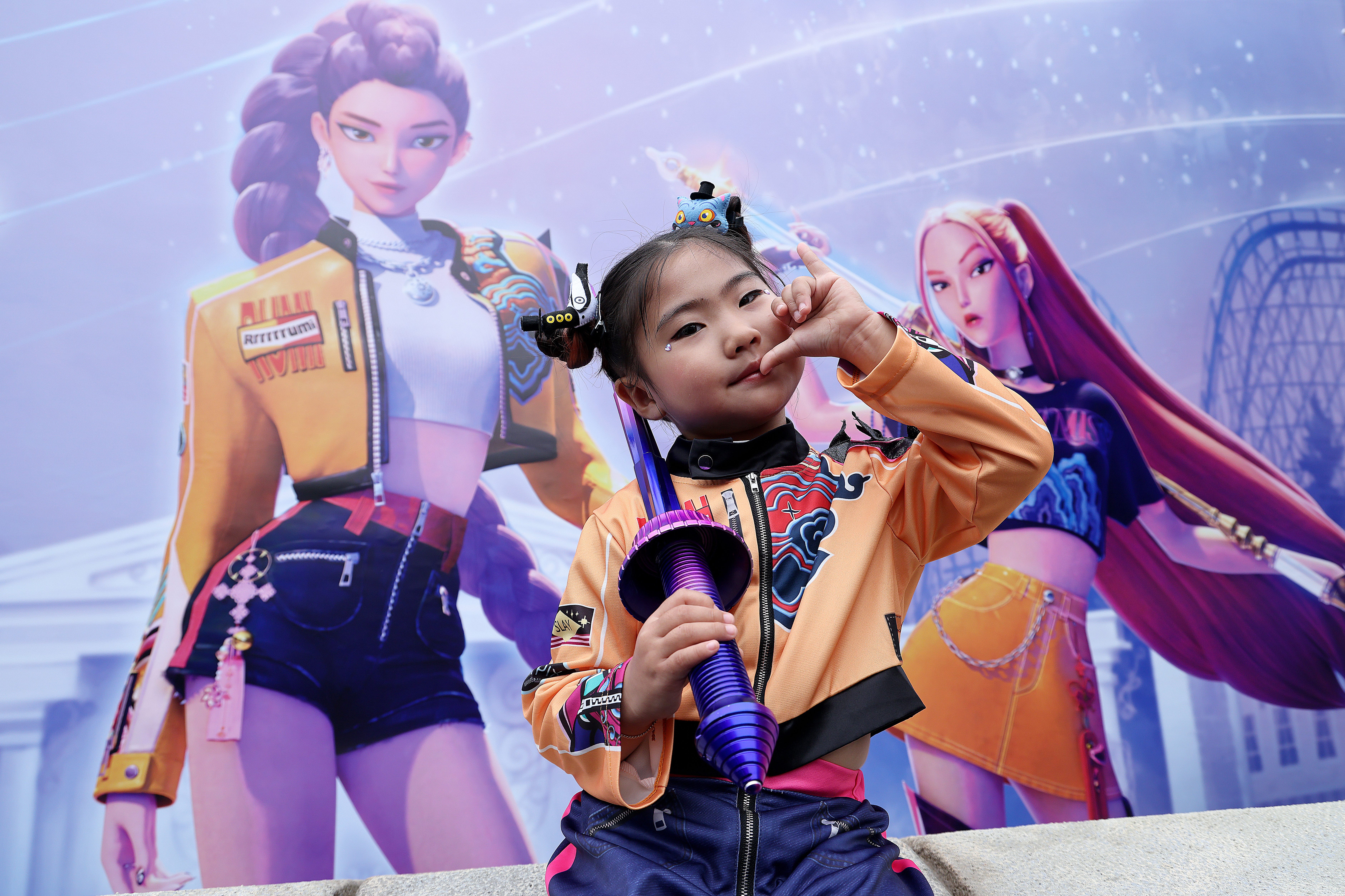a girl in front of a poster in k-pop demon hunters costume