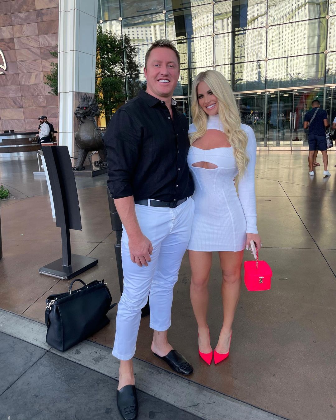 Kroy Biermann and Kim Zolciak posing in front of a building.