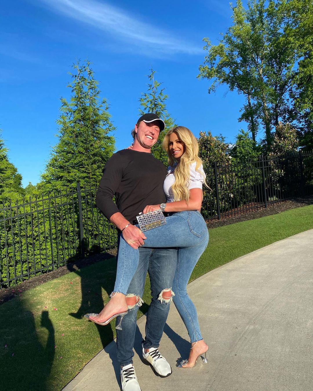 Kroy Biermann holding Kim Zolciak with her leg up.