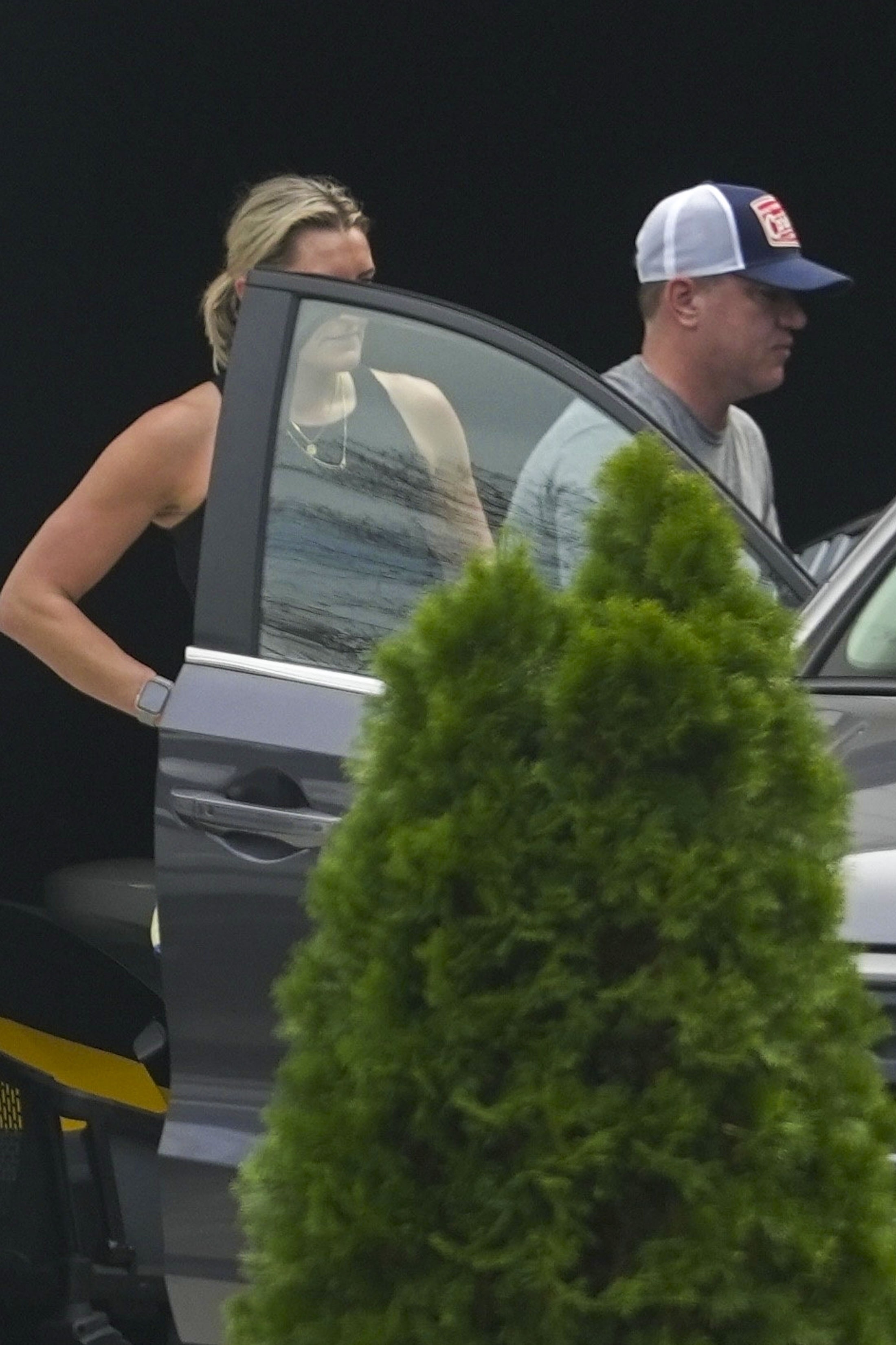 Kim Zolciak and Kyle Mowitz by a car.