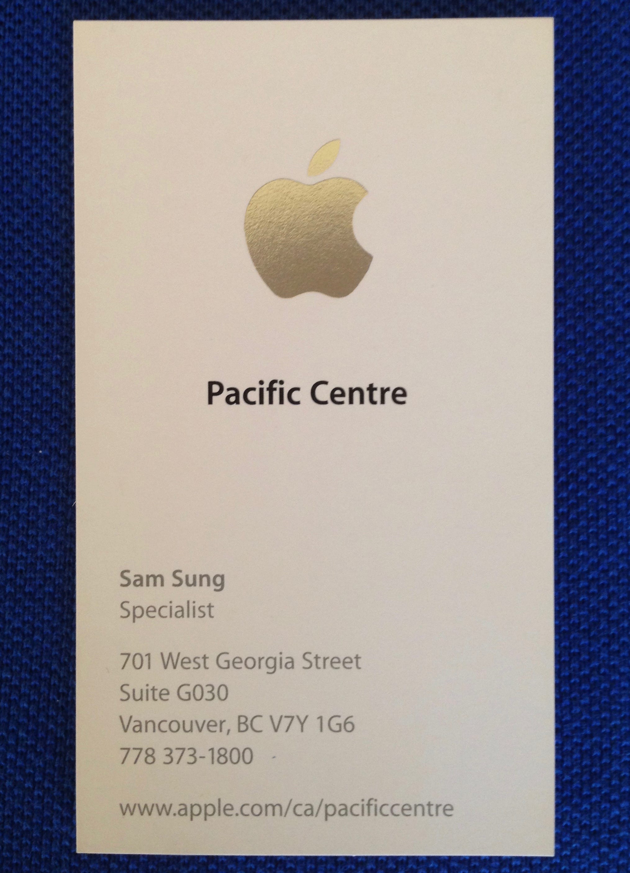 A business card with the Apple logo at the top, labeled