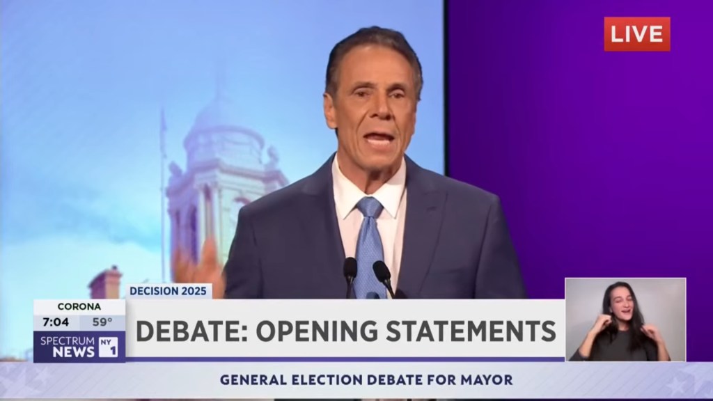 Andrew Cuomo speaking at a mayoral debate with an ASL interpreter.