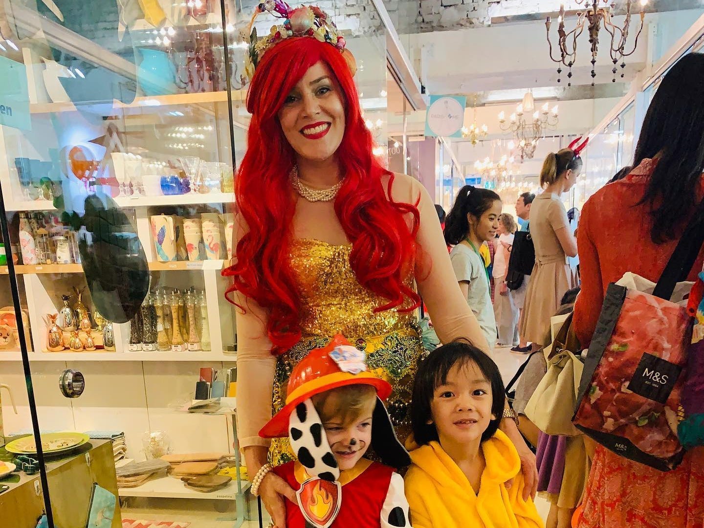 Sara Lyle dressed as a mermaid and posed with her son dressed up as a firefighter.