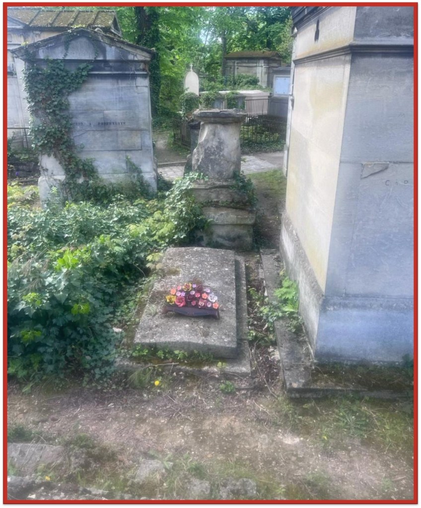 An overgrown cemetery with monuments and grave markers, with a floral arrangement on a flat tombstone in the foreground.