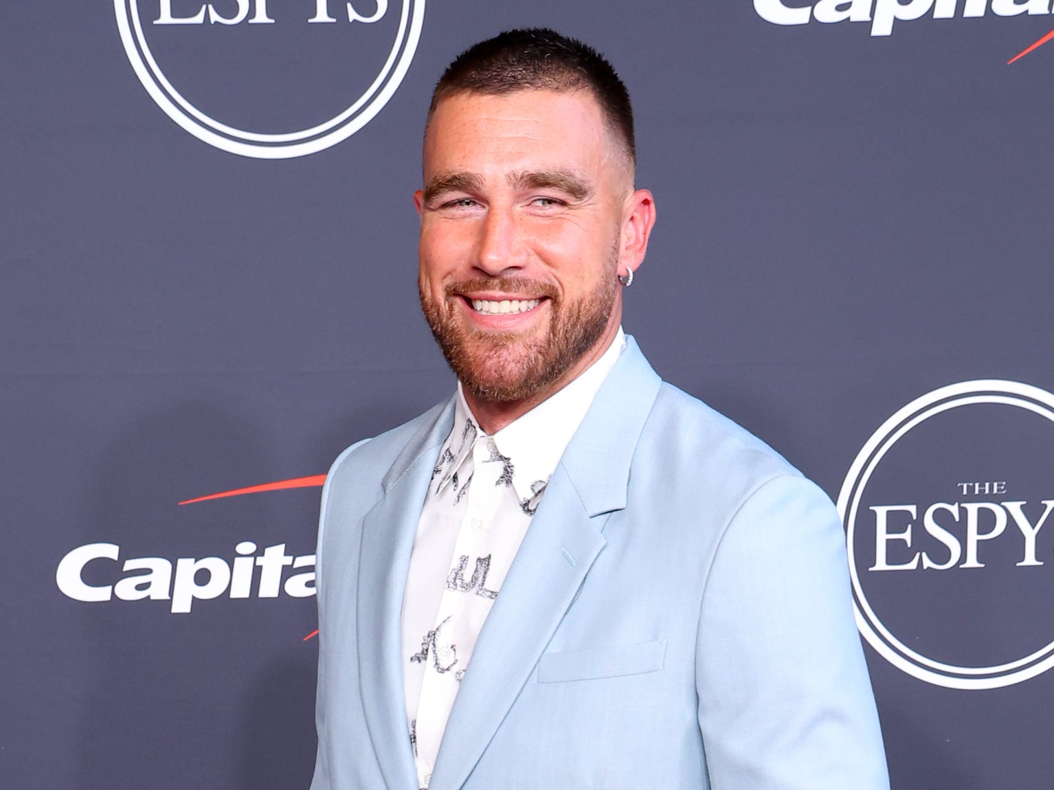 Travis Kelce wearing a powder blue suit over a patterned white button-up shirt.
