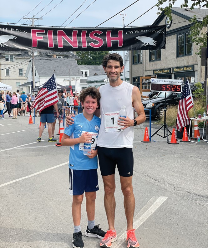 photo of man and child smiling at finish line of race