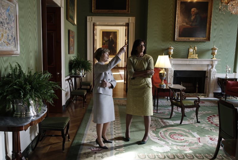 First Lady Laura Bush takes Michelle Obama for a private tour of the artwork in the East wing of the White House during a coffee morning with congressional leaders before Barack Obama is sworn in as the 44th president of the United States on January 20, 2009 in Washington, DC.
