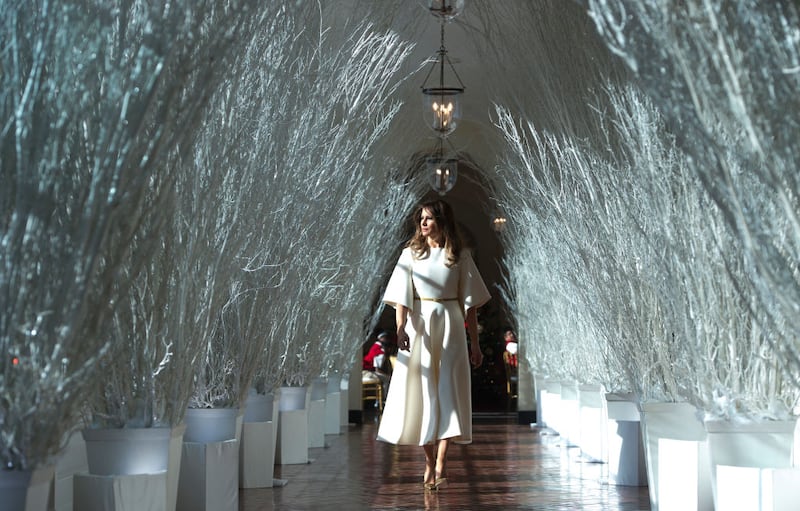 US First Lady Melania Trump walks through Christmas decorations in the East Wing as she tours holiday decorations at the White House in Washington, DC, on November 27, 2017.