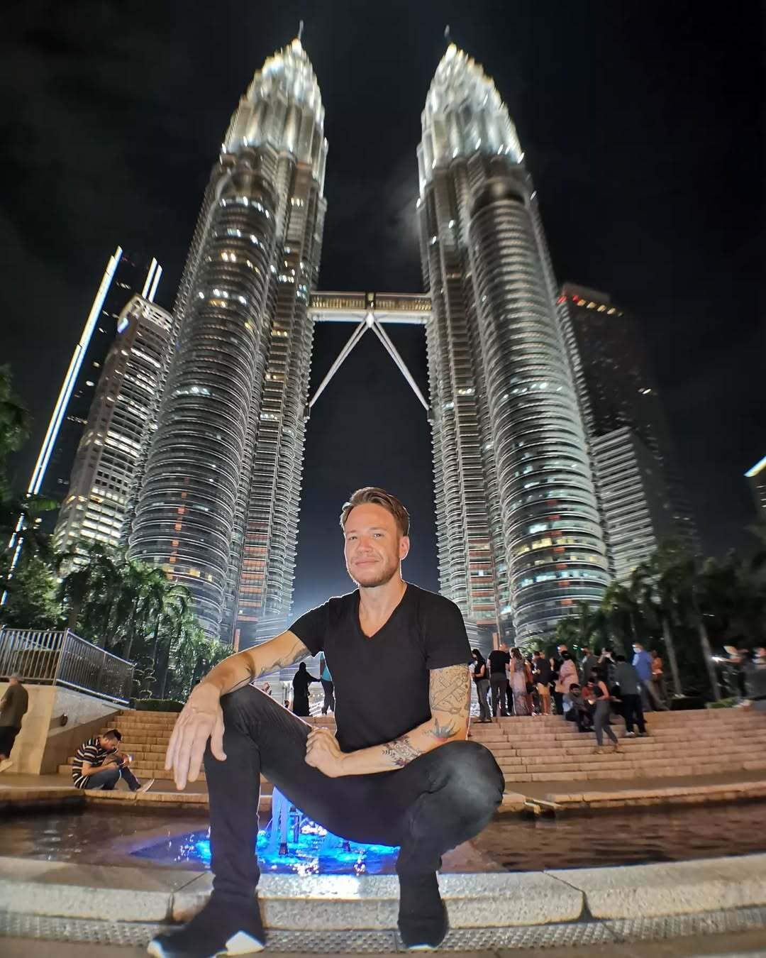 Andre Neveling posing outside the Petronas Towers in Kuala Lumpur, Malaysia.