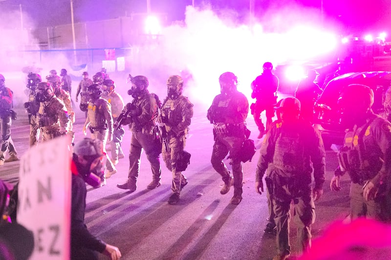 Federal law enforcement agents attack demonstrators protesting outside of an immigrant processing center with a barrage of tear gas and pepper balls
