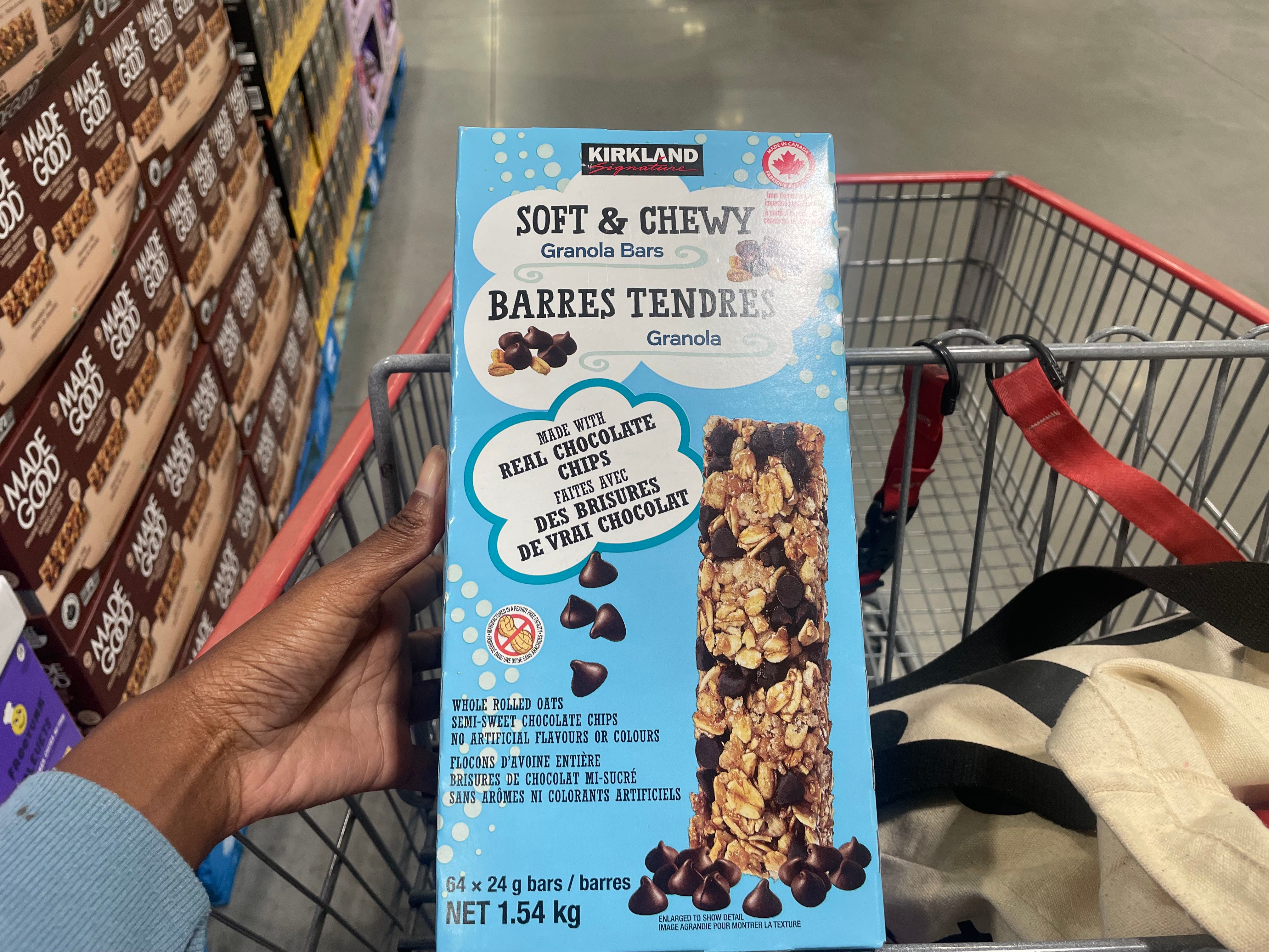 The author holding a box of Kirkland Signature chocolate chip granola bars.