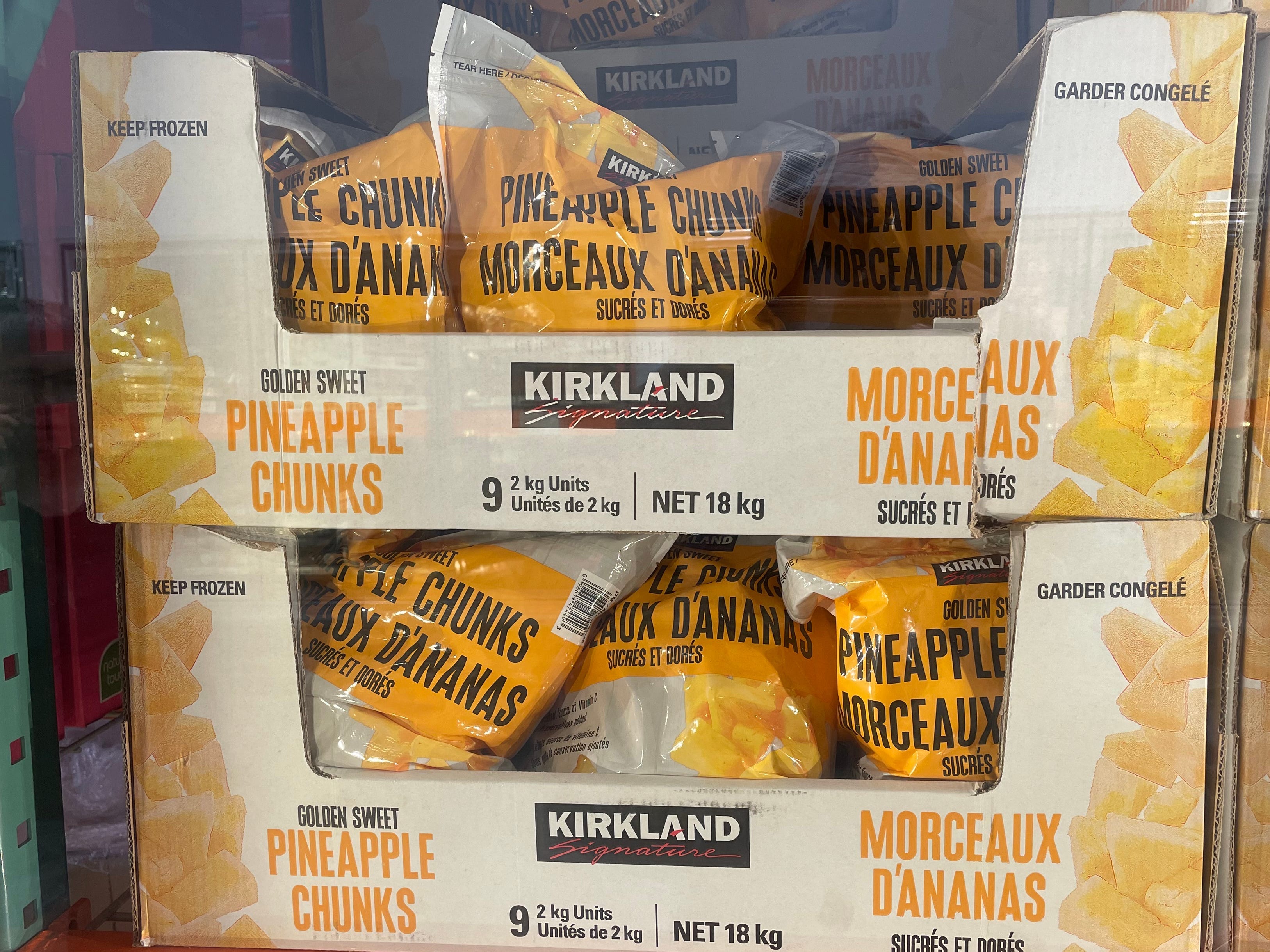 A display of bags of Kirkland Signature pineapple chunks.