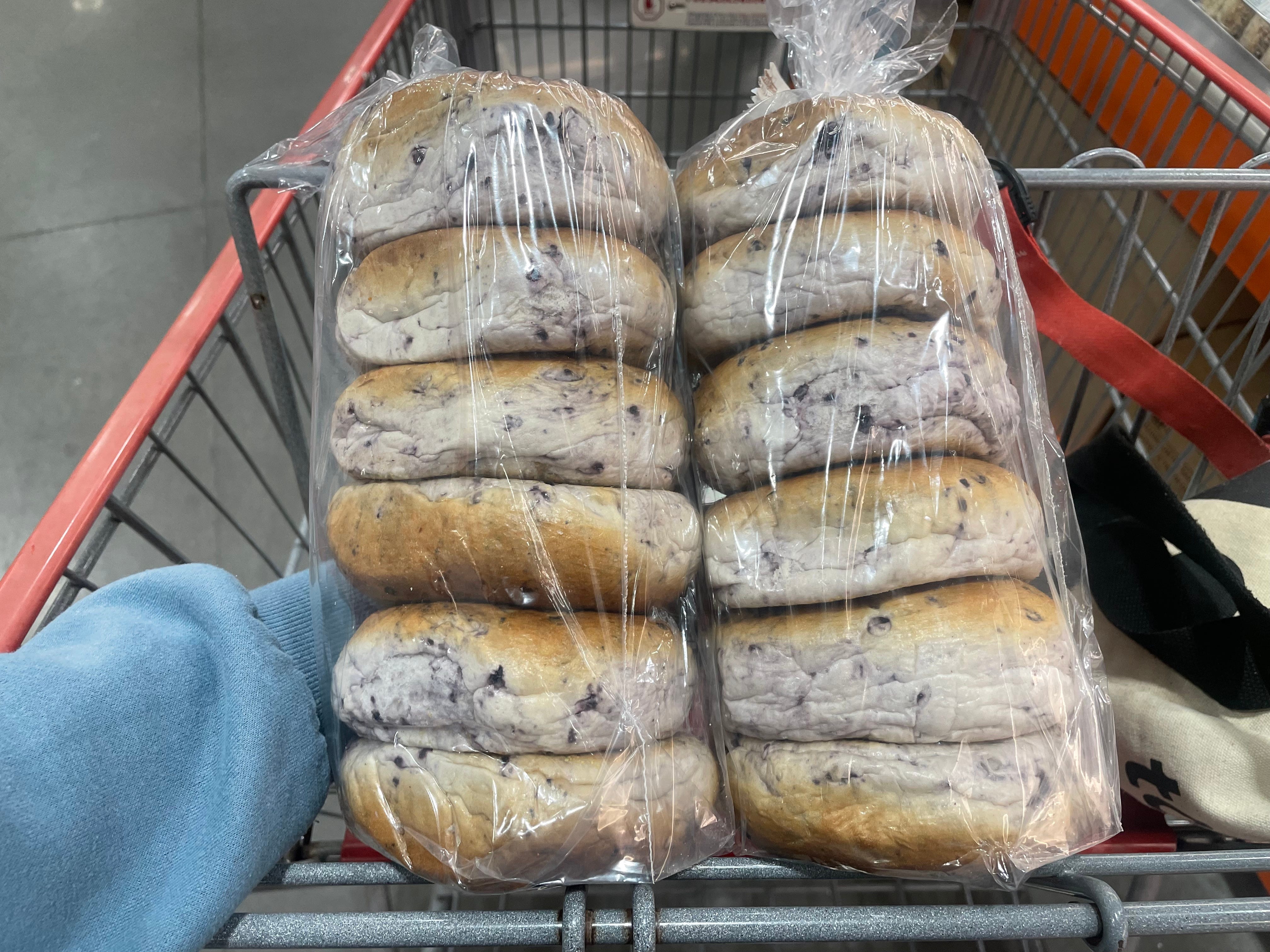 The author holding two bags of blueberry bagels.