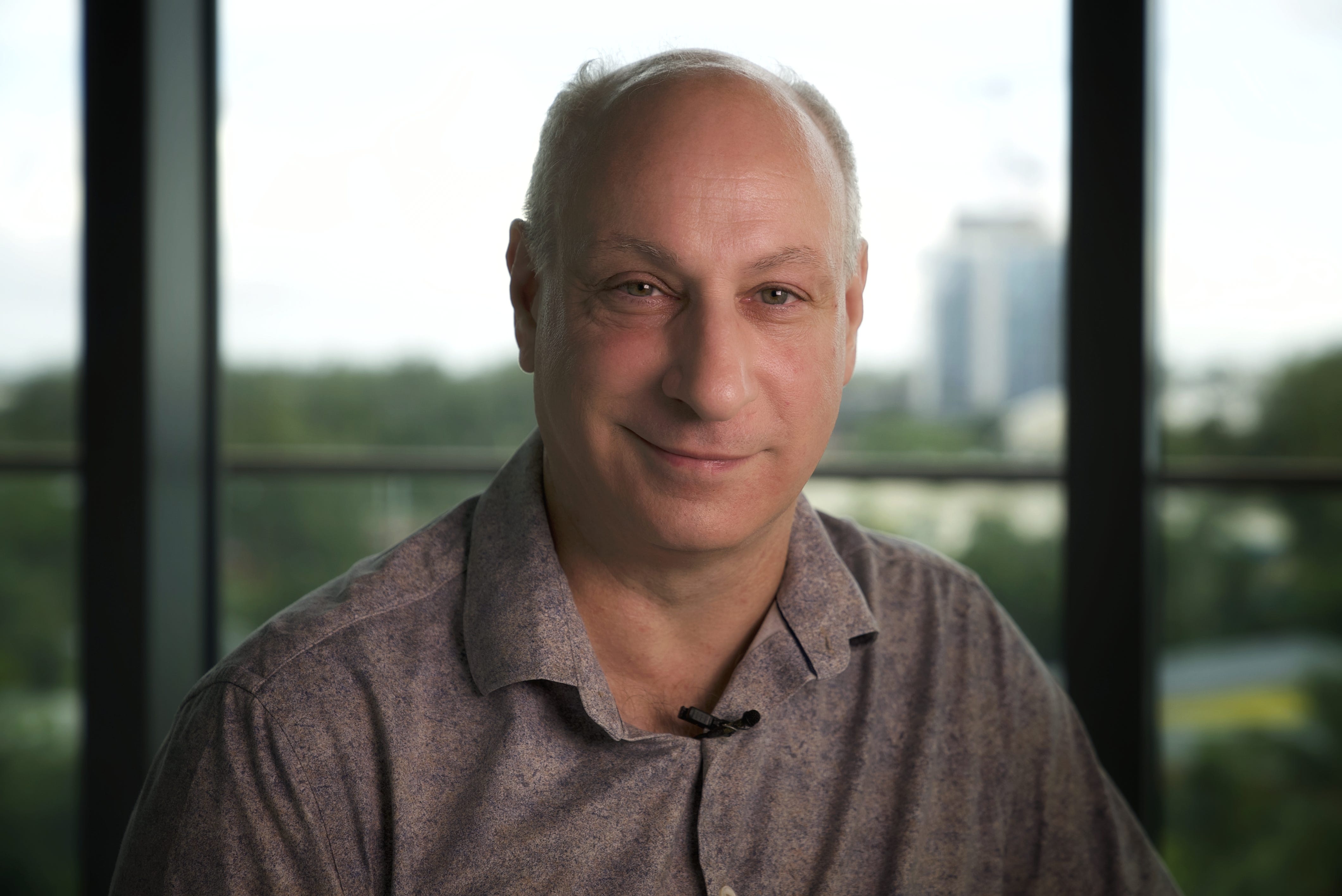 A man in a polo shirt smiles for the camera