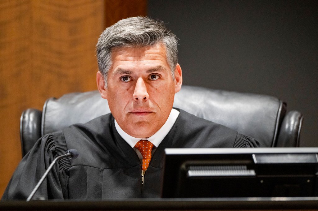 Judge Tony Graf in a black robe and orange tie looks directly ahead.