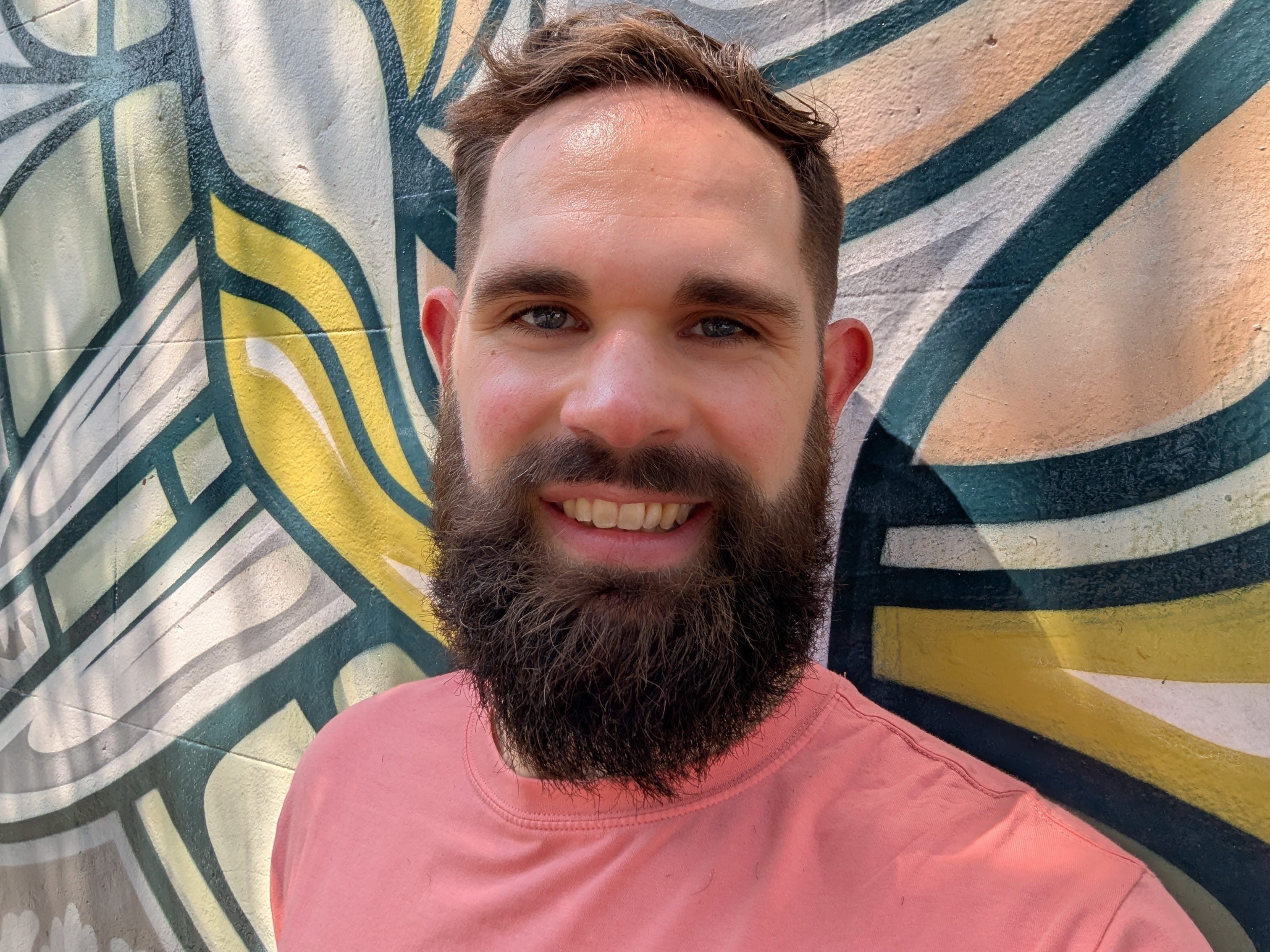 Filer standing in front of a colorful wall mural.