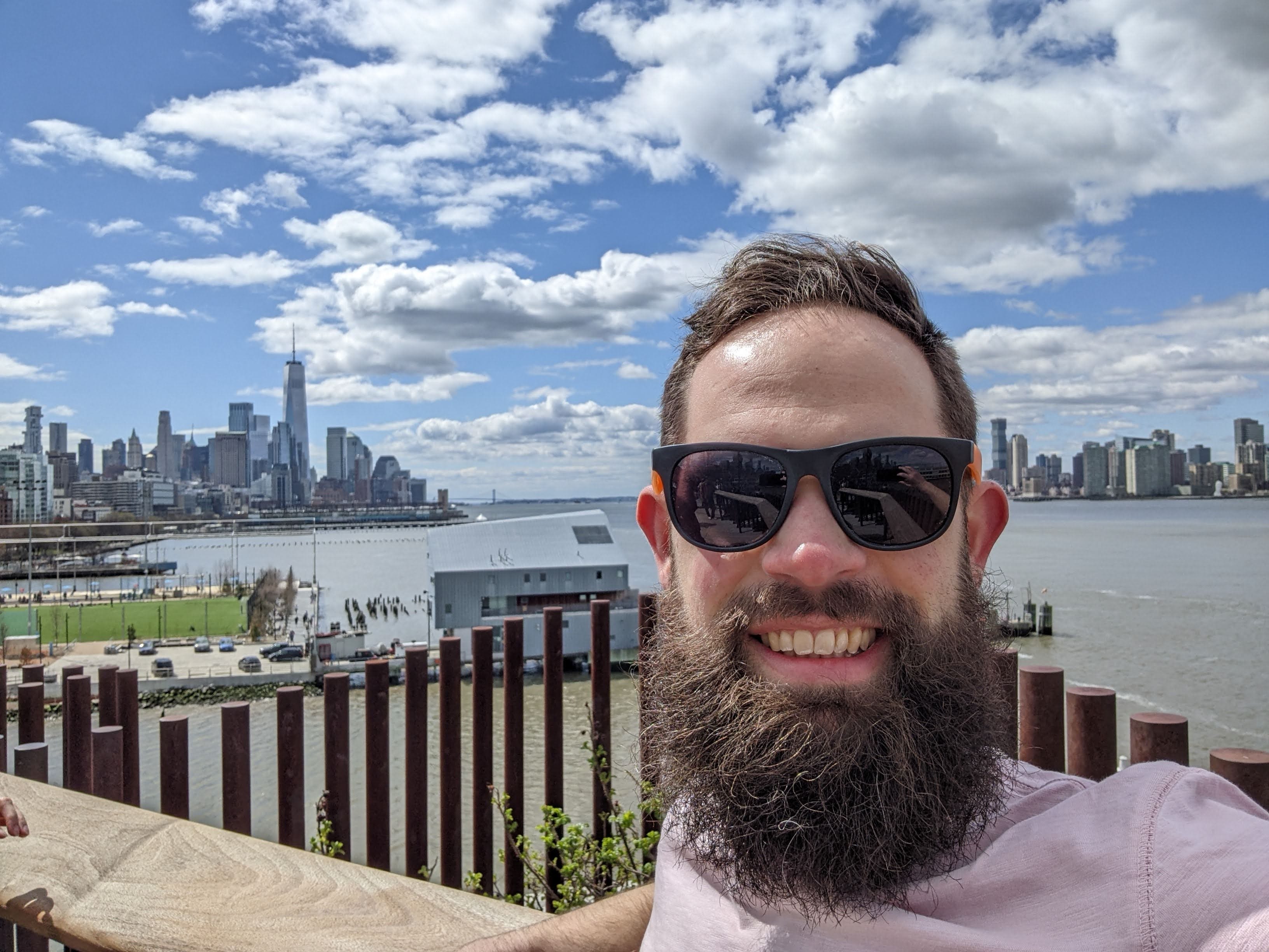 Gabriel Filer standing outdoors in front of a body of water and some buildings.