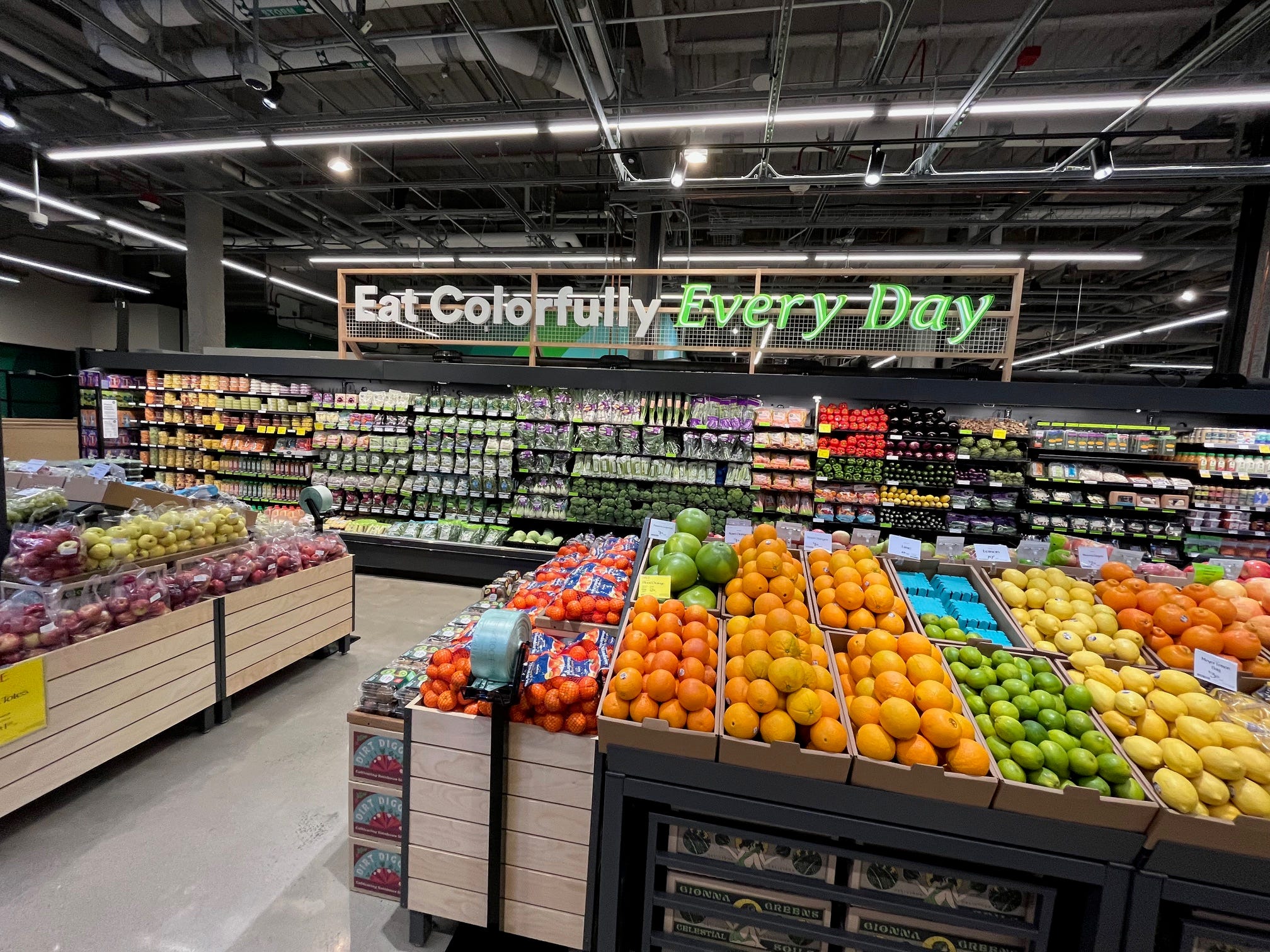 A sign above the produce section at a Whole Foods Daily Shop store reads: