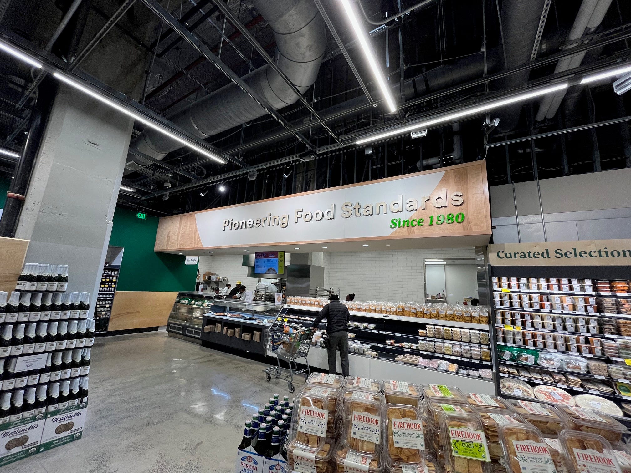 A sign above the deli section of Whole Foods Daily Shop reads: