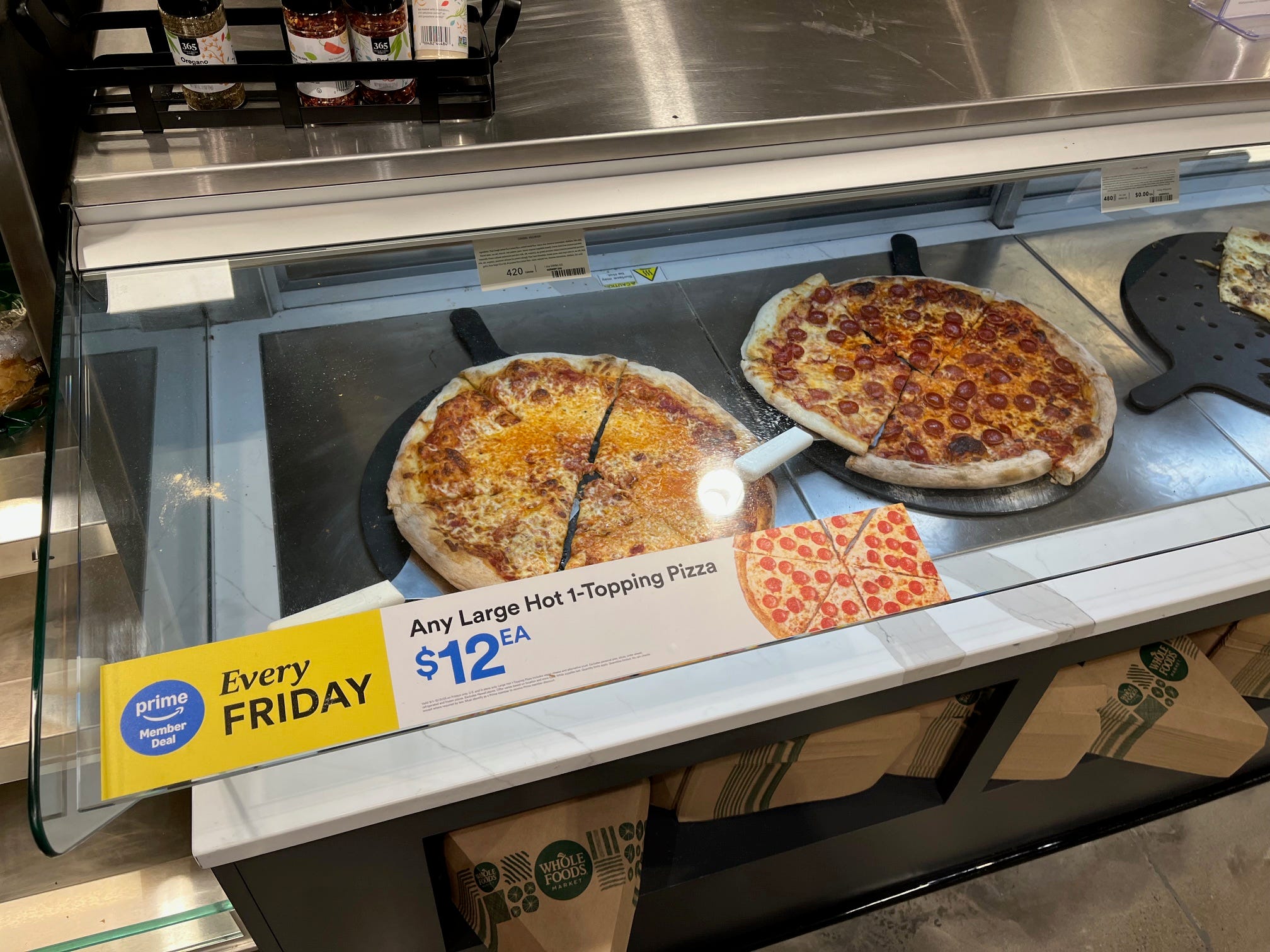 Slices of pizza sit on a warming counter at Whole Foods Daily Shop