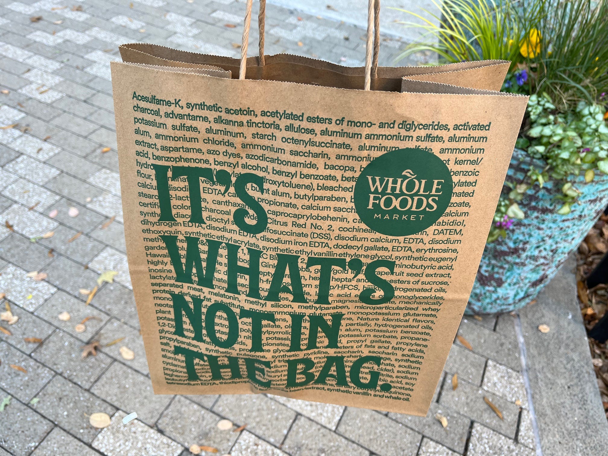 A paper bag from Whole Foods Daily Shop reads