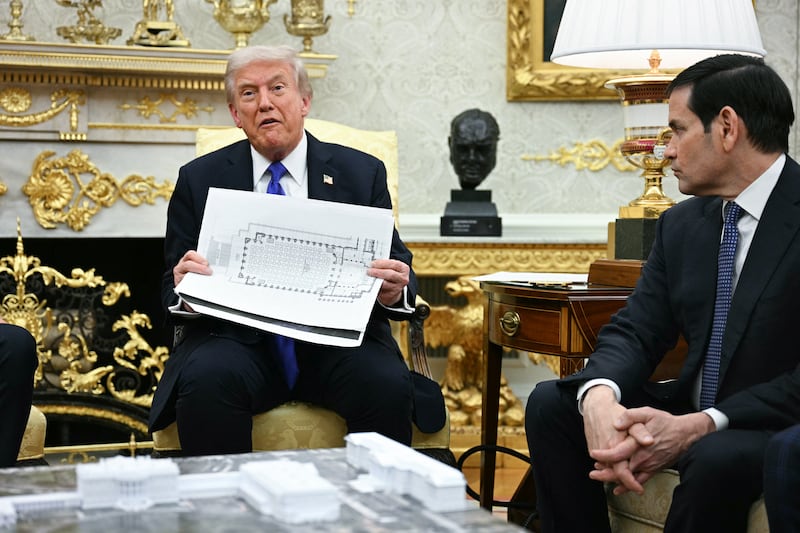 US President Donald Trump shows the floor plan of his planned ballroom as he meets with NATO Secretary General Mark Rutte in the Oval Office of the White House in Washington, DC, on October 22, 2025.