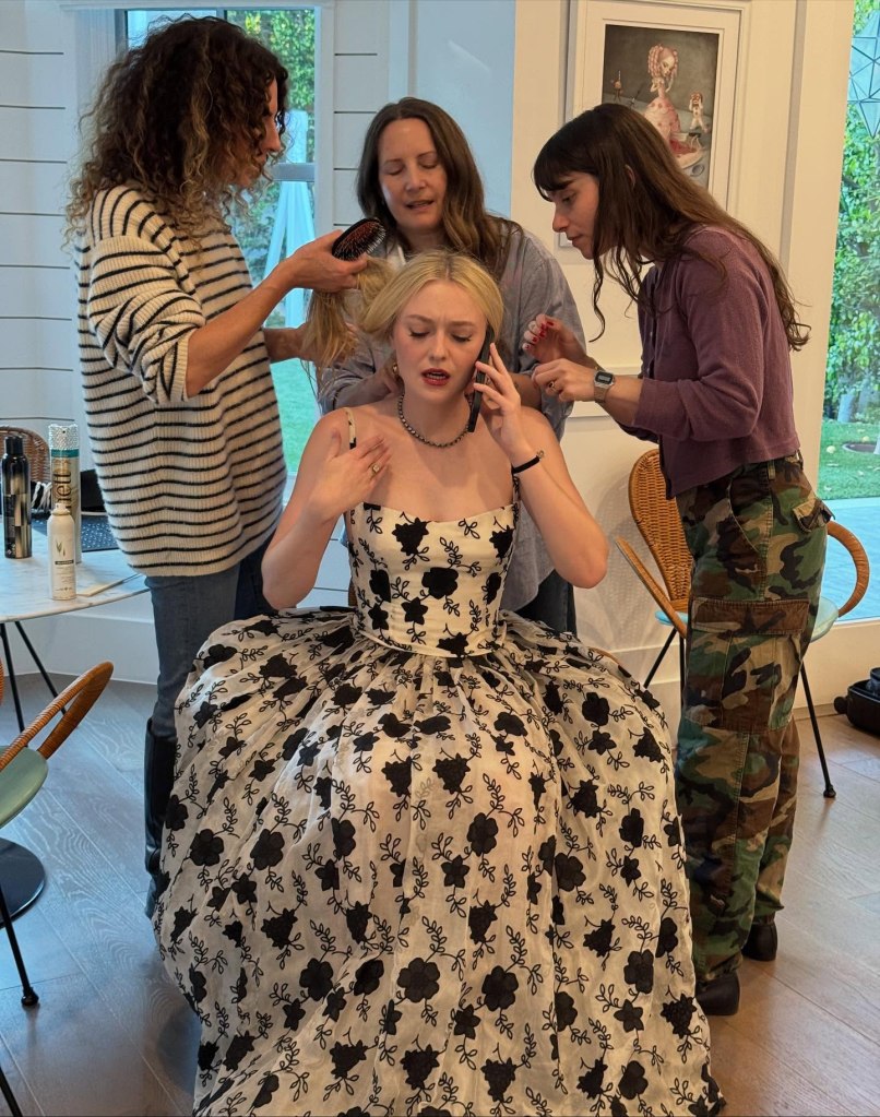 Many hands rustle Dakota Fanning,  in archival 1996 Armani, into a camera-ready state for a gala at the Academy Museum in LA.
