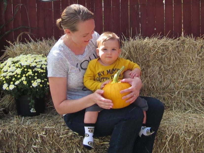 The author poses with her son when he was 10 months old.