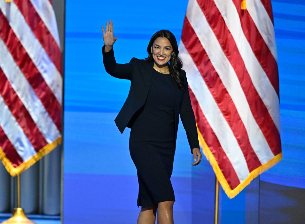 Alexandria Ocasio-Cortez waving on stage at the Democratic National Convention.
