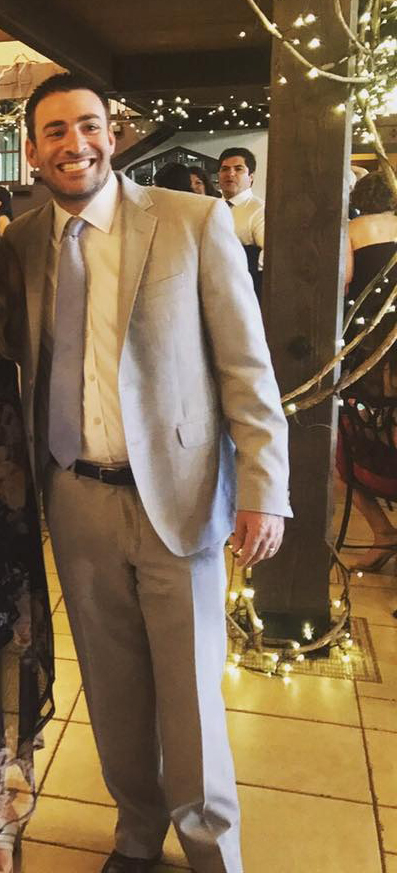 Scott Semaya, a Marlboro, NJ school board candidate, smiling while wearing a light-colored suit and tie.