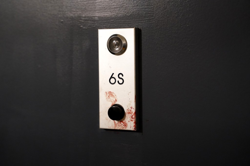 Bloody handprints on the door of Apartment 6S.