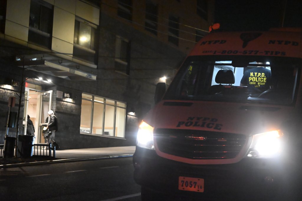 An NYPD Crime Scene Unit van parked outside of 1010 East 173rd Street at night.