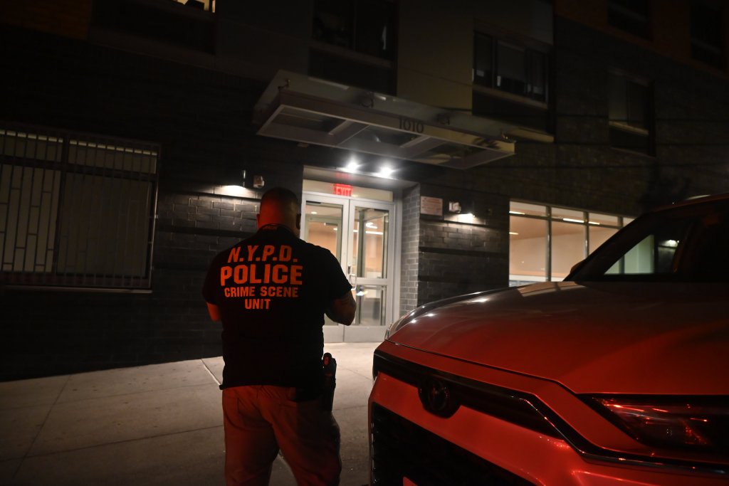 An NYPD Crime Scene Unit officer stands outside 1010 East 173 Street in the Bronx.