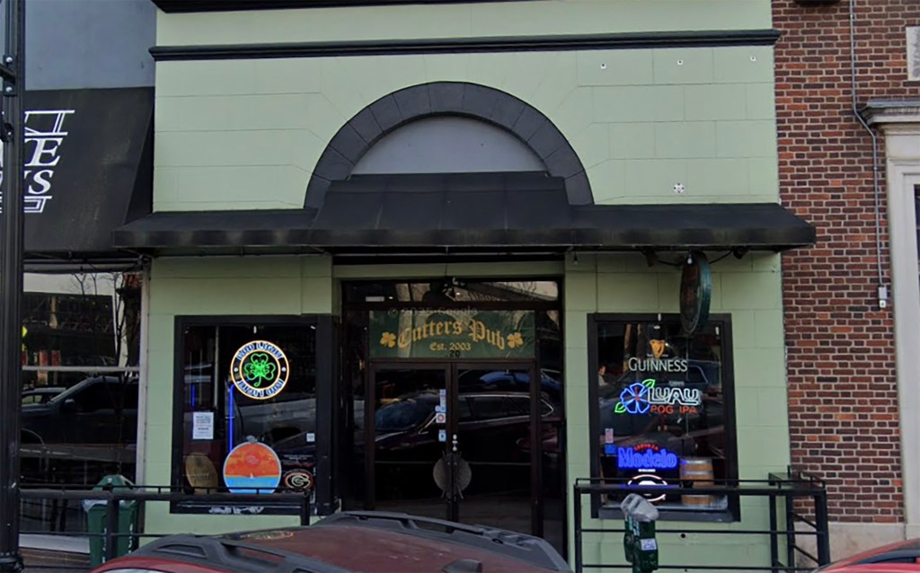 The exterior of Cutters Pub at 120 E Clayton St, Athens, GA 30601, showing its entrance, windows with neon signs, and a black awning.